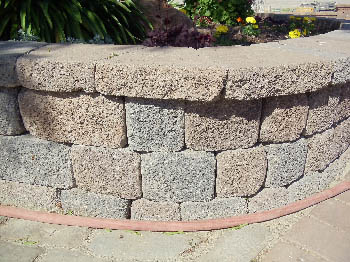 Engineered interlocking concrete block retaining wall for hillside erosion control
