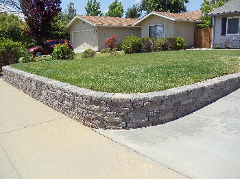 Engineered interlocking concrete block retaining wall for hillside erosion control
