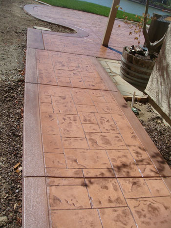 Curved stamped concrete walkway with charcoal border in Elk Grove, CA